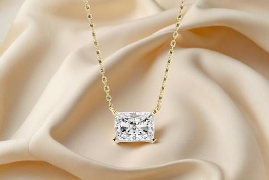 Gold necklace with a diamond pendant on a soft beige fabric background