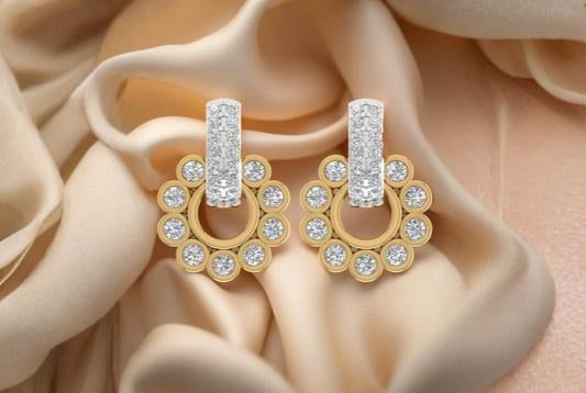 Gold and diamond earrings on a beige fabric background