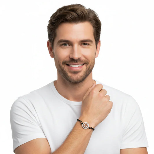 Man wearing silver diamond alphabet G bracelet on black cord, luxury jewelry for men