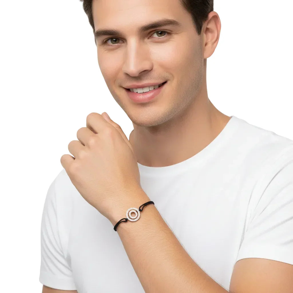 Man wearing diamond alphabet O silver bracelet with black cord, white background