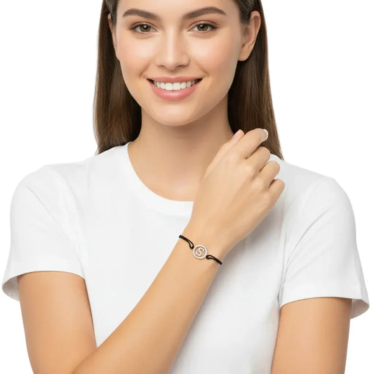 Woman wearing a silver diamond alphabet S bracelet on a black cord