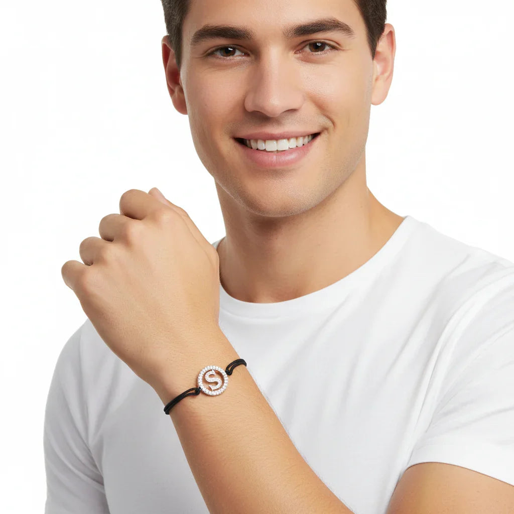 Man wearing silver diamond letter S bracelet with black cord on wrist