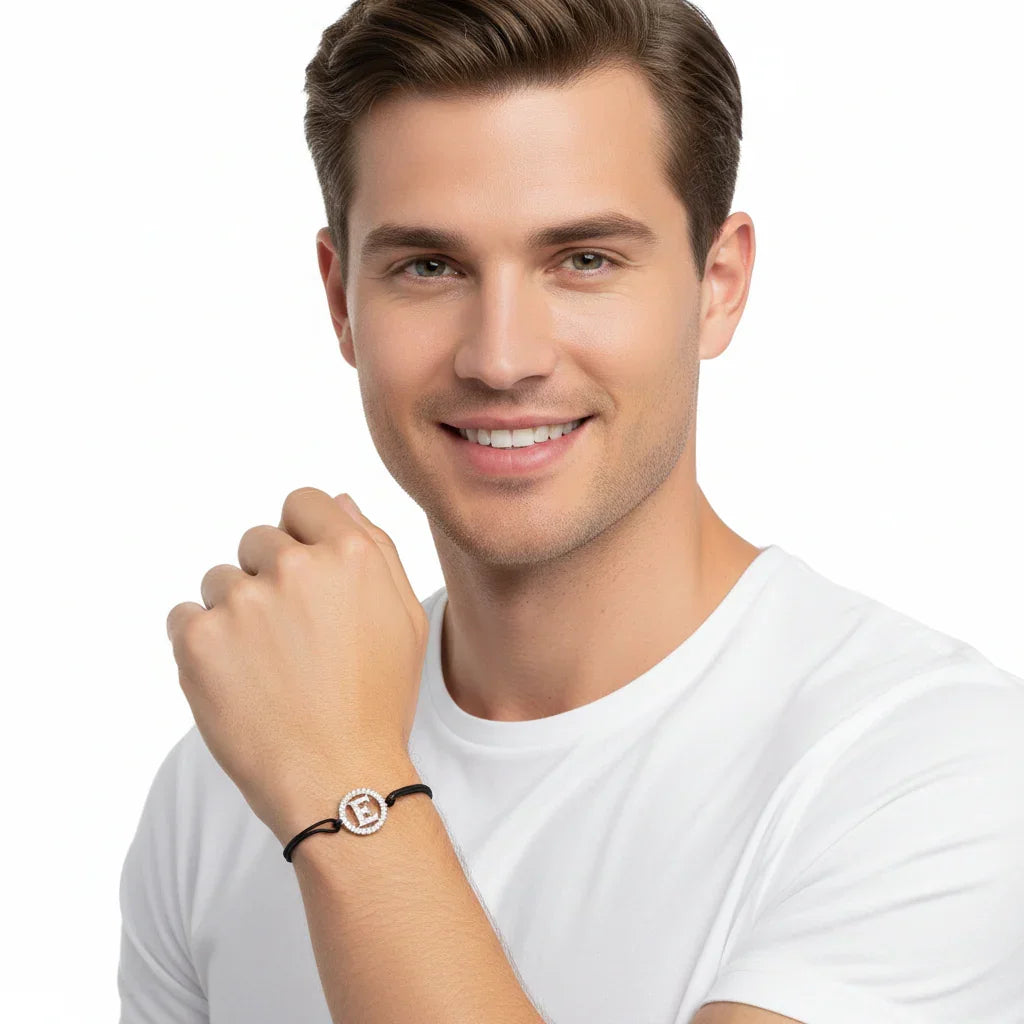 Man wearing a silver diamond alphabet E bracelet with black adjustable strap