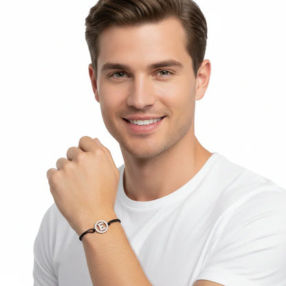 Man wearing a silver diamond alphabet E bracelet with black adjustable strap