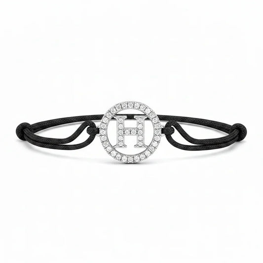 Silver diamond alphabet H bracelet with black adjustable cord on white background