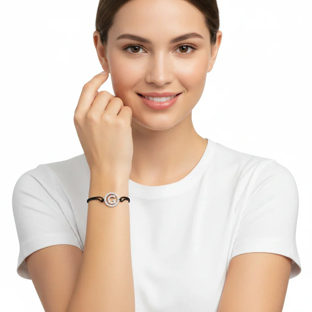 Woman wearing silver diamond alphabet G bracelet with black adjustable band