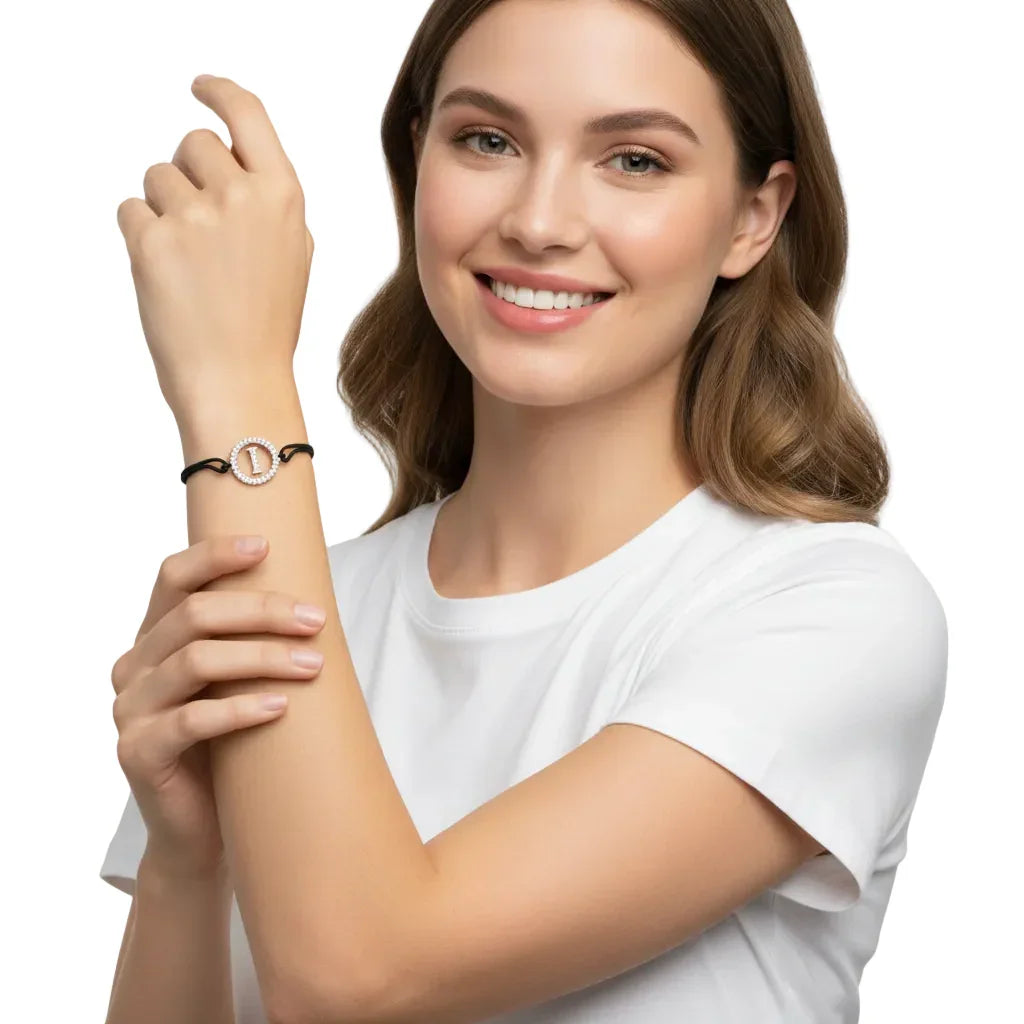 Woman wearing a silver diamond alphabet I bracelet on black cord, closeup on wrist