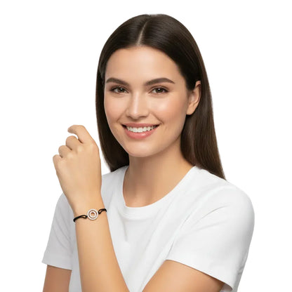 Woman wearing a silver diamond alphabet O bracelet with black cord on wrist