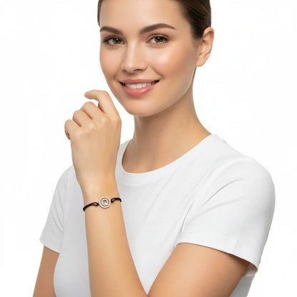 Woman wearing silver diamond alphabet Q bracelet on black cord, elegant jewelry fashion.