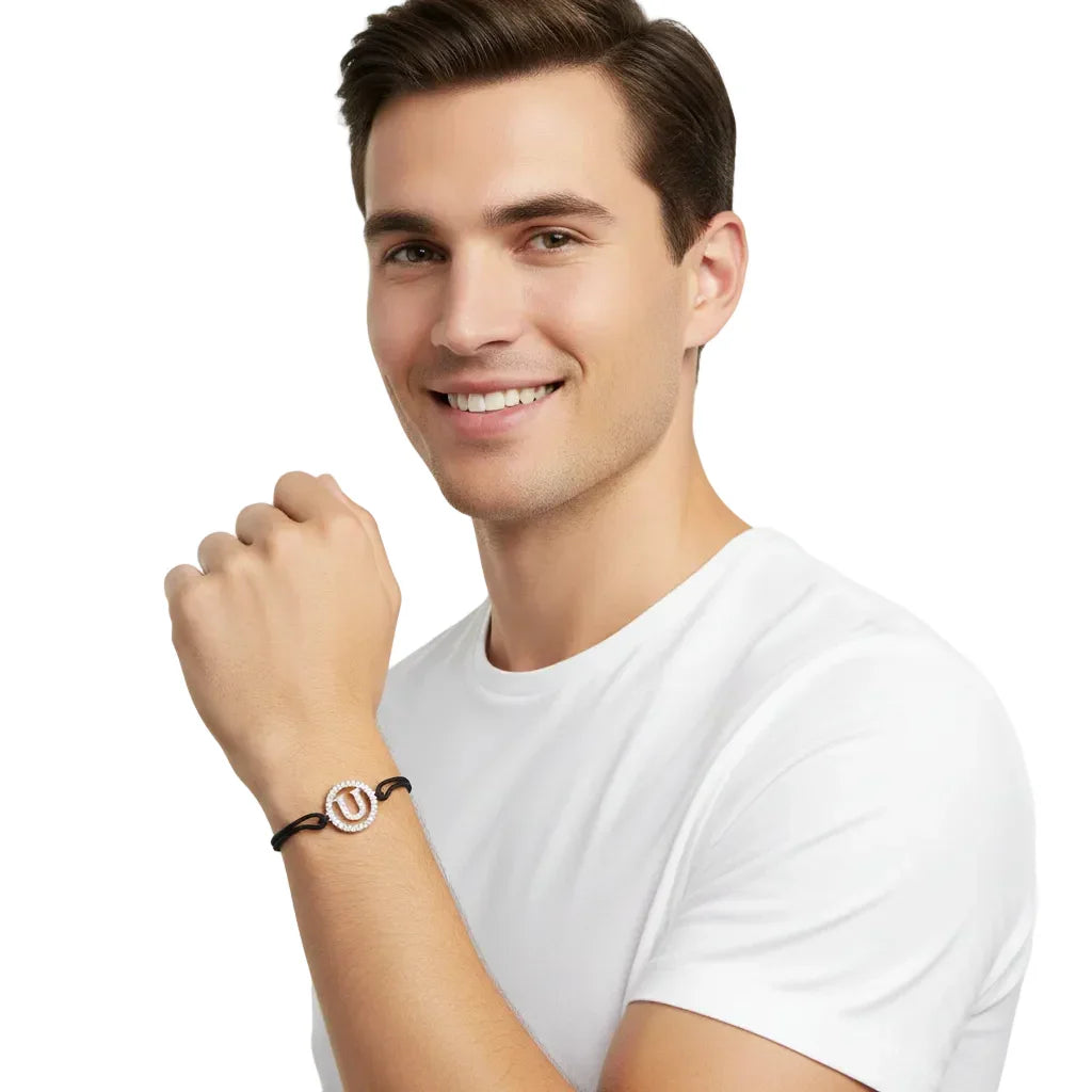 Man wearing a silver diamond bracelet with alphabet U charm on black cord