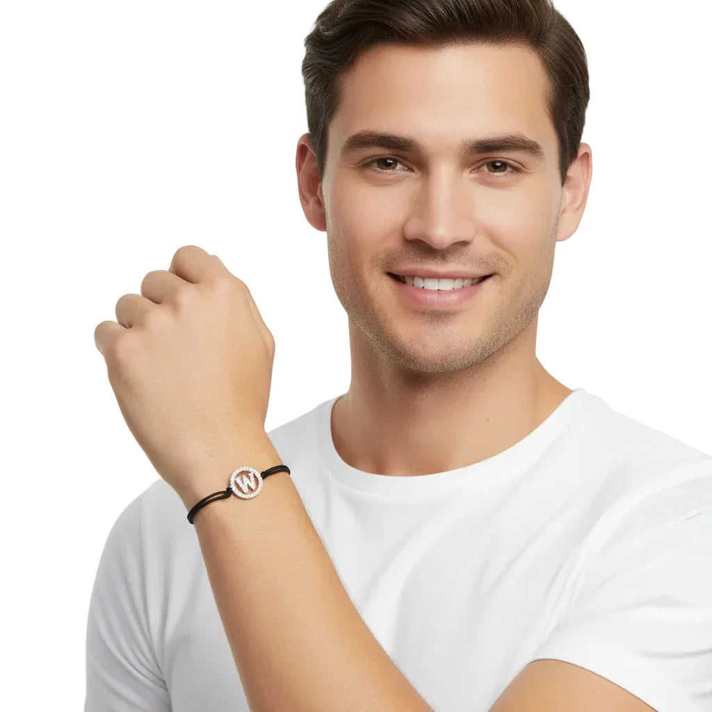 Man wearing black cord bracelet with silver diamond alphabet W charm