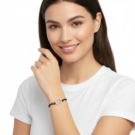 Woman wearing a diamond initial A bracelet with black band, white background