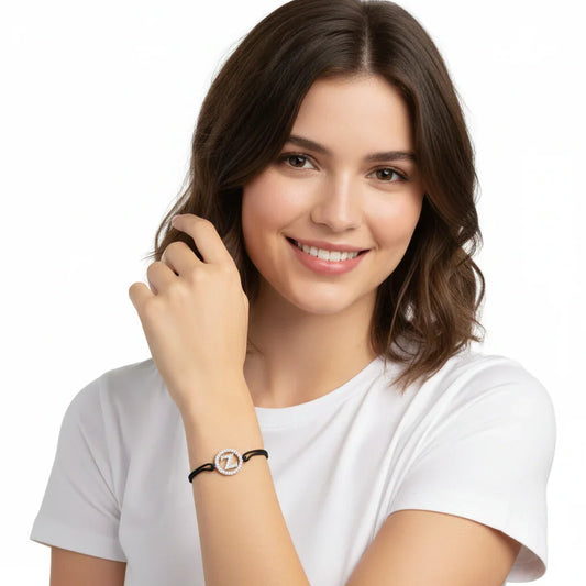 Woman wearing elegant diamond-encrusted initial 'Z' bracelet on black cord, perfect for everyday style.