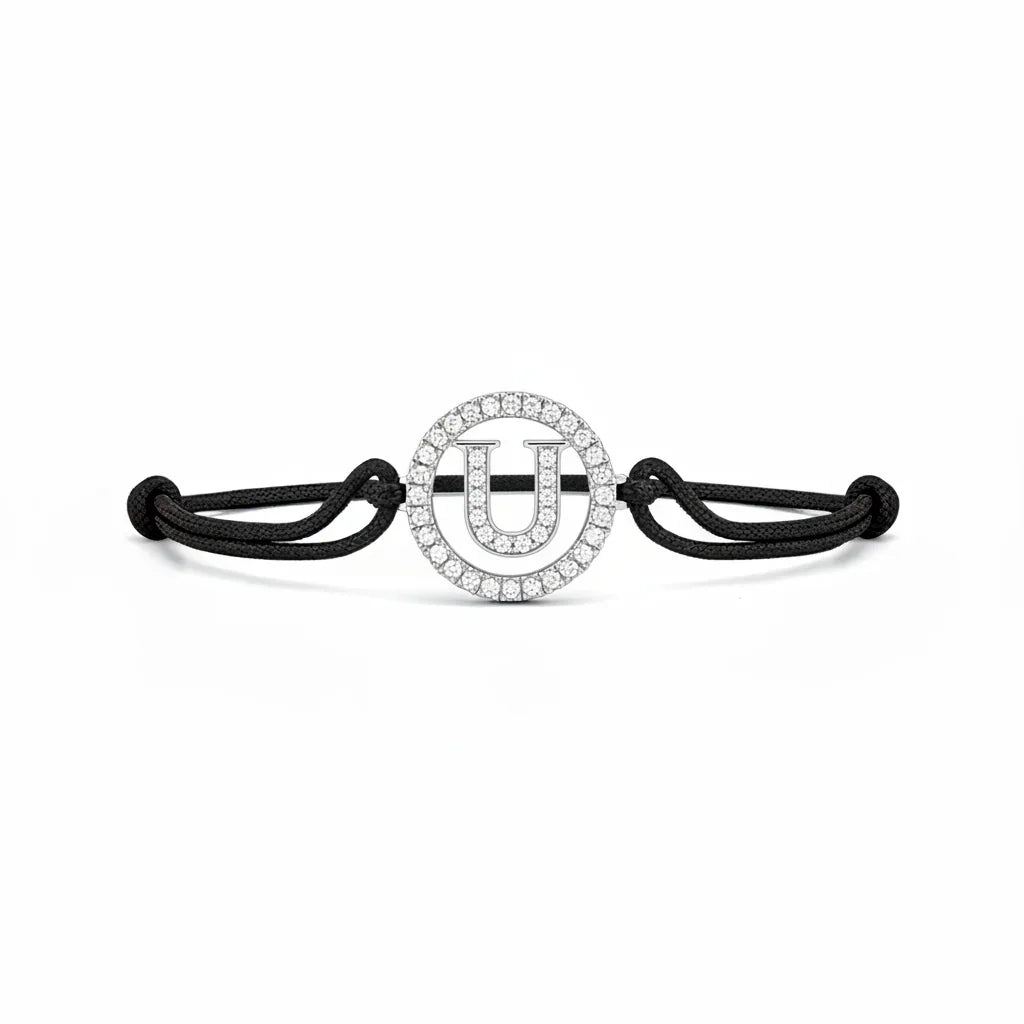 Silver diamond alphabet U bracelet with black adjustable cord on white background
