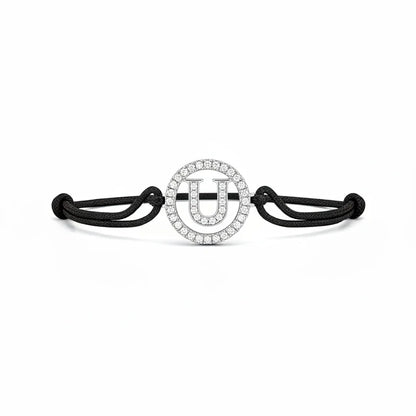 Silver diamond alphabet U bracelet with black adjustable cord on white background